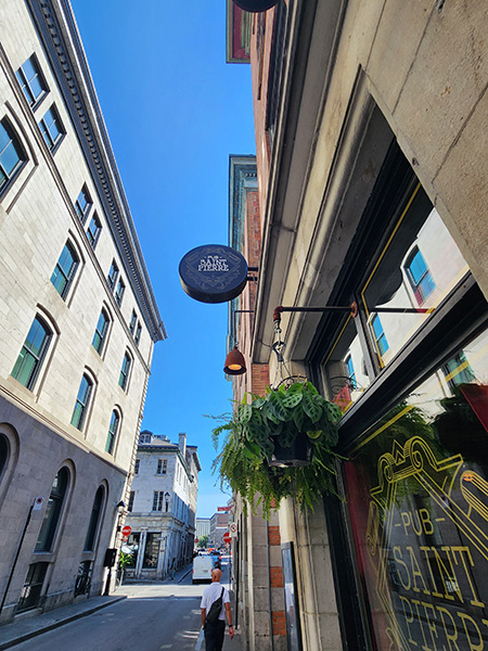 photo of Montreal street with Dave walking, in front of a pub